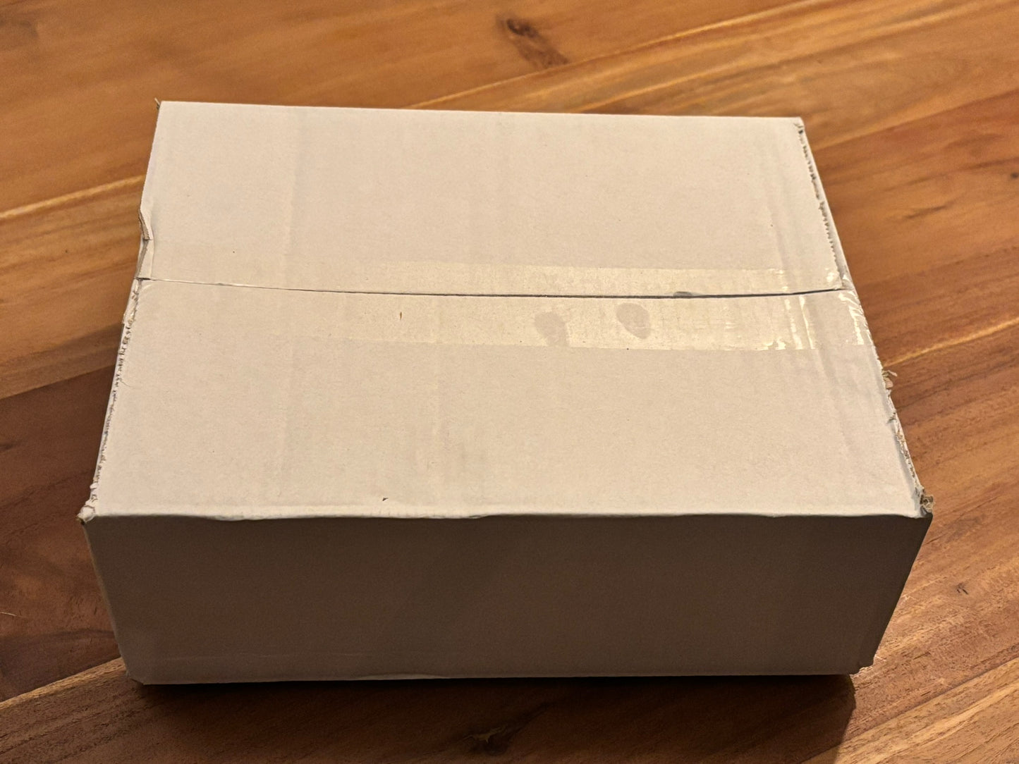 Een witte, dichte doos op een houten tafel