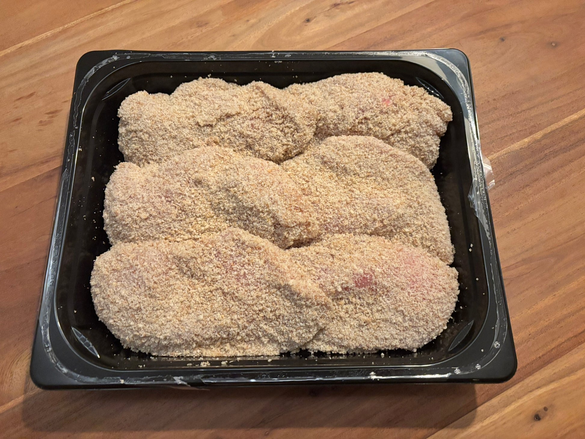 Zes verse, rijk gevulde kip cordon bleu's in een zwarte verpakking